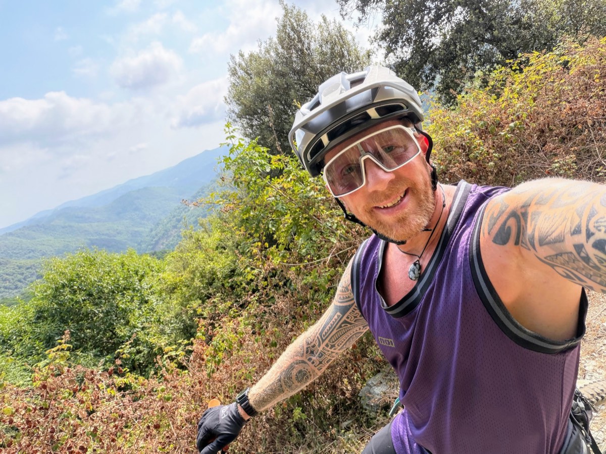 Mike Hinnen with helmet and bike glasses on a trail, selfie